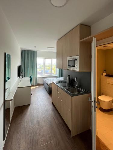 a kitchen with a sink and a microwave at Studio Apartment über den Wolken in Berlin