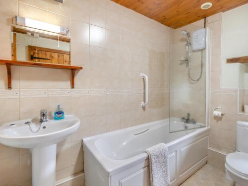 a bathroom with a sink and a tub and a toilet at 2 Bed in Trefin 94123 in Trevine