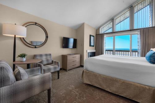 a bedroom with a bed and a large window at Schooner's Cove Inn in Cannon Beach