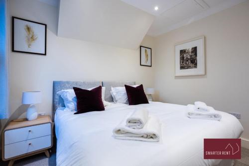 um quarto com uma cama branca e toalhas em 1 Bedroom Apartment - Central Richmond-upon-Thames em Richmond upon Thames