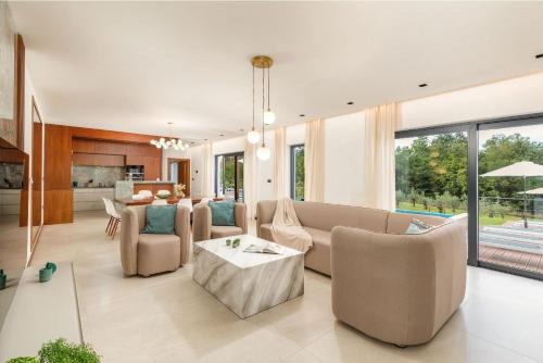een woonkamer met een bank, stoelen en een tafel bij Villa Istria Green in Kršan