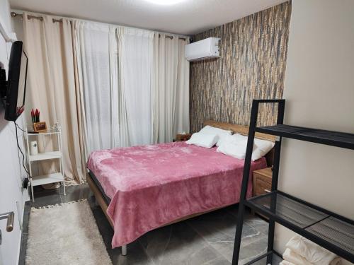 een slaapkamer met een bed met een roze deken bij Pampering Beach Dream, A Stunning Luxury Retreat in Menevi