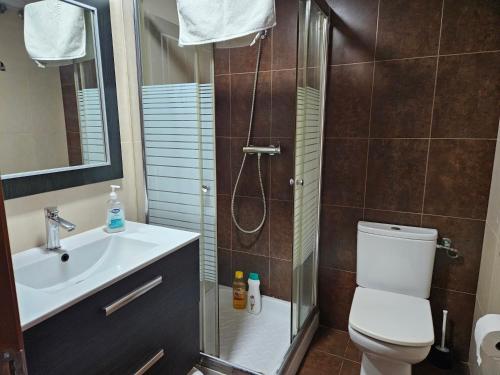 y baño con ducha, aseo y lavamanos. en Apartamentos Irina, en Gandía