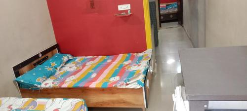 Cette chambre comprend 2 lits et une porte rouge. dans l'établissement Manchaman home stay, à Ujjain