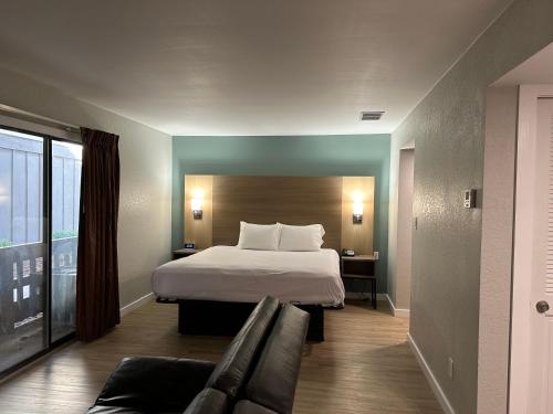 une chambre d'hôtel avec un lit et un canapé dans l'établissement MainStay Suites, à Springfield