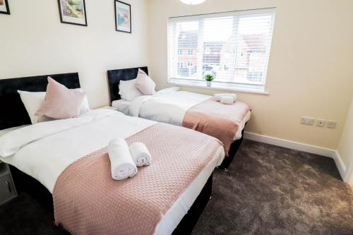 twee bedden in een kamer met een raam bij 3BR House with Parking near Iron Pier Thames River in Woolwich