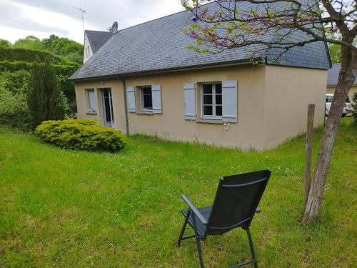 een zwarte stoel in het gras voor een huis bij La curieuse petite maison in Vendôme