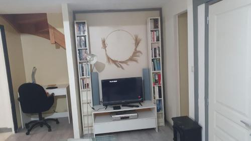 a room with a desk and a television and a chair at Appartement La Garance, Gites de Daumesnil in Morlaix