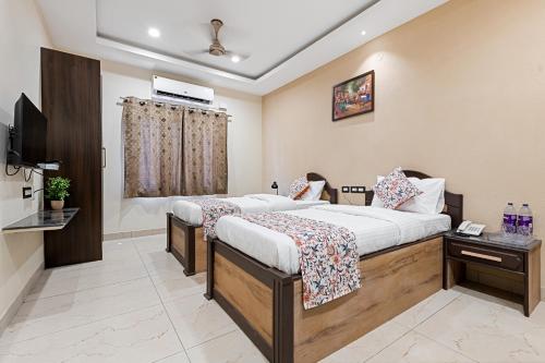 a hotel room with two beds and a television at VEERA RESIDENCY in Tiruvallūr