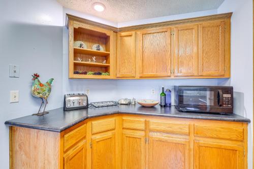 a kitchen with wooden cabinets and a microwave at Dog-Friendly Michigan Home with Deck and Fire Pit! in Central Lake