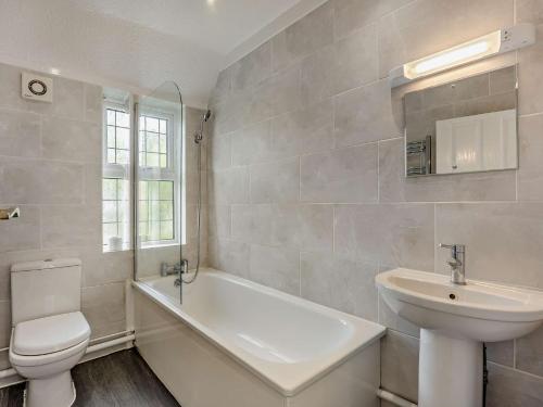 a bathroom with a sink and a toilet and a bath tub at 3 Bed in Bognor Regis 93447 in Bognor Regis