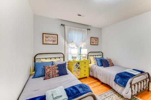 sypialnia z 2 łóżkami i żółtą komodą w obiekcie Elizabeth City Abode with Fenced Yard, Near Downtown w mieście Elizabeth City