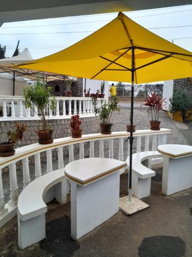 un parapluie jaune assis au-dessus d'un banc dans l'établissement Hôtel les Cygnes II, à Antananarivo