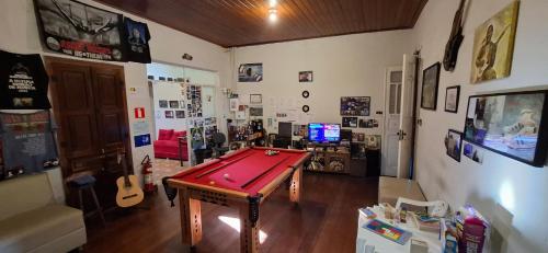 a room with a pool table in the middle of a room at La Musica Hostel OuroPreto in Ouro Preto