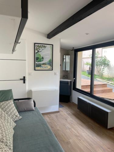 une chambre avec un lit et une grande fenêtre dans l'établissement Studio Vichy Marol, à Vichy