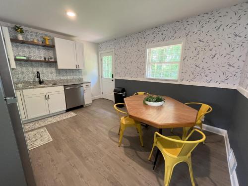 a kitchen with a wooden table and yellow chairs at Sapphire Shire in Winston-Salem