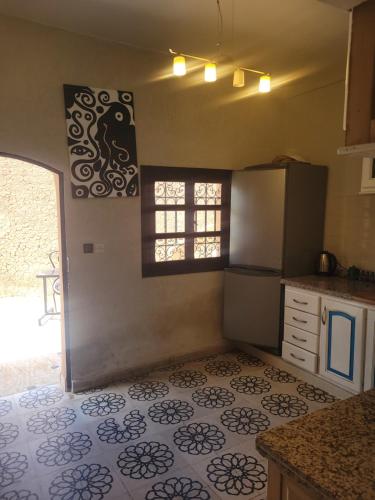 cocina con nevera y suelo de baldosa. en Villa Ama en Marrakech
