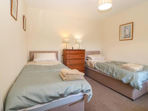 a bedroom with two twin beds and a dresser at Ty Mawr in Gaerwen