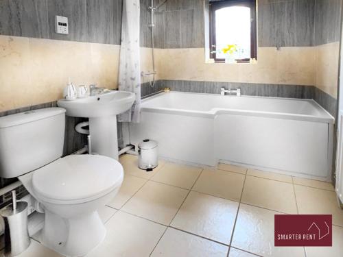 a bathroom with a toilet and a tub and a sink at Hitchin - St Anne's - 2 bed coach house & Parking in London Colney