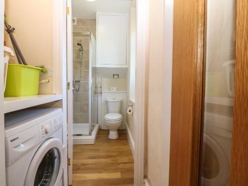 a bathroom with a toilet and a washing machine at Ty Mawr in Gaerwen