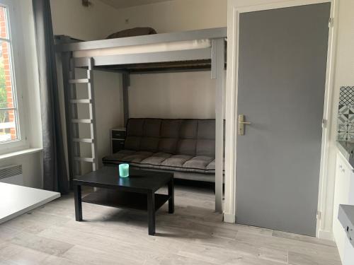 - un salon avec des lits superposés et une table basse dans l'établissement Studio à 100m à pied de la plage et de la digue du sillon, à Saint-Malo