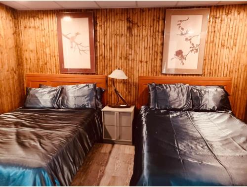 two beds in a room with wood paneling at Falls Motel in Niagara Falls