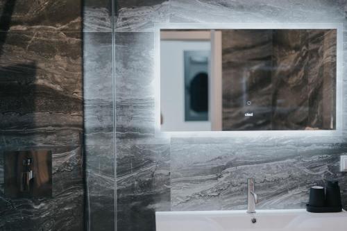 een badkamer met een wastafel en een spiegel bij Villa Luxe by Atlantic Holiday in Ribeira Brava