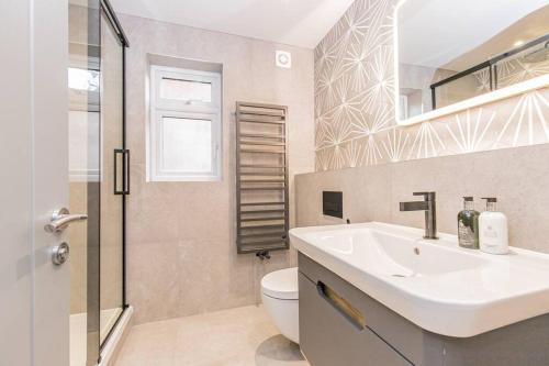 a white bathroom with a sink and a toilet at Flat 1, 161 Crescent Road Luxury Apartment in Oxford