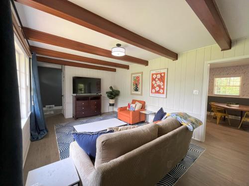 a living room with two couches and a flat screen tv at Sapphire Shire in Winston-Salem