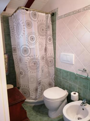 uma casa de banho com um WC e uma cortina de chuveiro em La Casina di Anna em Porto Vecchio