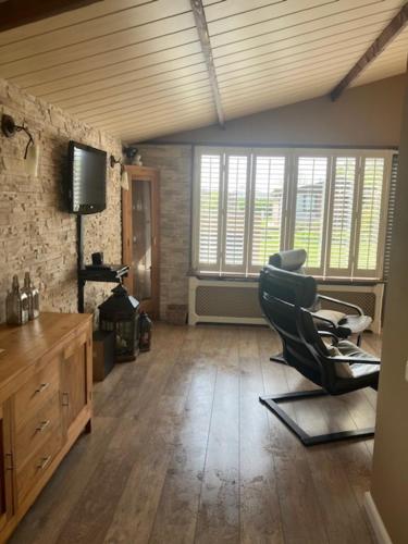 a living room with a chair and a television at Het andere huisje in Warmenhuizen