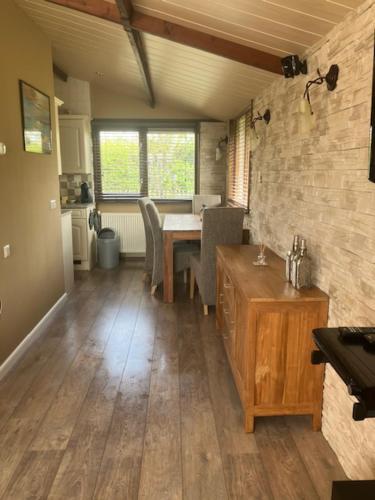 a living room with a table and a dining room at Het andere huisje in Warmenhuizen