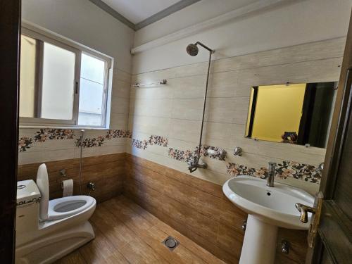 a bathroom with a toilet and a sink and a mirror at Hotel Versa Appartment Gulberg in Lahore