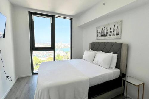 Un dormitorio blanco con una cama grande y una ventana en Miami Biscayne Bay Fortress! High Rise Water Views, Lux!, en Miami