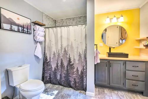 a bathroom with a toilet and a shower curtain with trees at New! Charming Bingham Home Near Outdoor Adventure! in Bingham