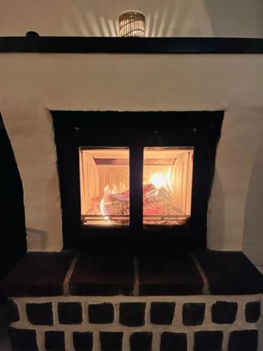 a fire in a fireplace in a room at Korsvirkeslänga in Helsingborg