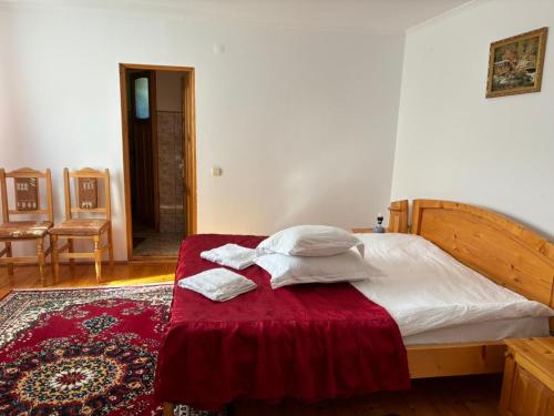 a bedroom with a bed with two towels on it at Pensiunea Luminita in Bran