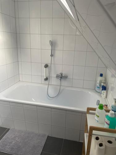 a white bath tub with a shower in a bathroom at Familie Alber 2P in Elze