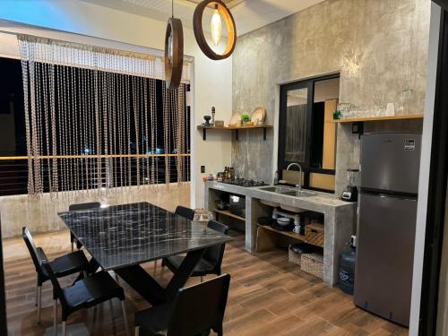 een keuken met een tafel en een koelkast bij Penthouse kavali in Los Ayala