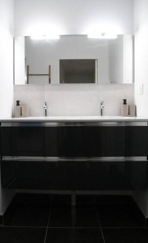 une salle de bain avec deux lavabos et un grand miroir dans l'établissement Flik-en-flac - Appartement à 20m de la plage, à Roscoff