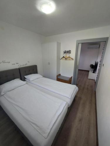 a bedroom with a large bed with white sheets at SPRING APT with garden and FREE secure parking in Domžale
