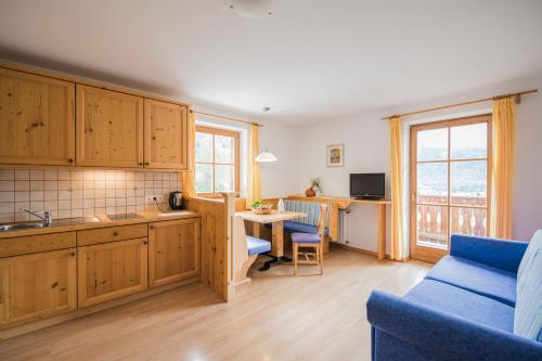 a kitchen with wooden cabinets and a blue couch at Klaudehof in Dobbiaco