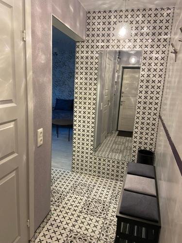 a bathroom with a hallway with a mirror and a staircase at Losiku apartamenti in Ventspils