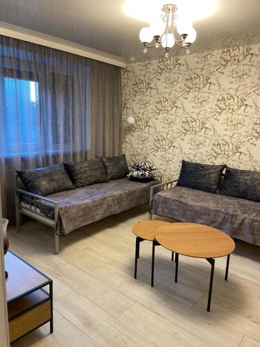 a living room with a couch and a table at Losiku apartamenti in Ventspils