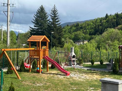 a playground with a slide and a swing set at Vikendica Bosnjak in Sarajevo
