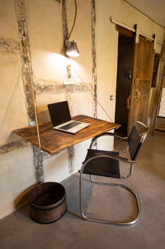 a desk with a laptop computer on top of it at Domaine De Chantemerle B'nB in Marsac