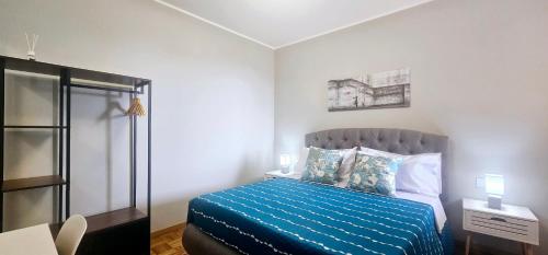 a bedroom with a bed with a blue comforter at Porta Mazzini Central Rooms in Bagnacavallo