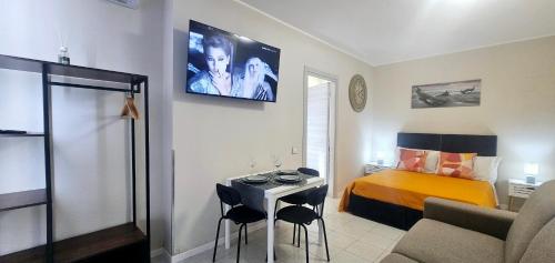 a small room with a bed and a table with chairs at Porta Mazzini Central Rooms in Bagnacavallo