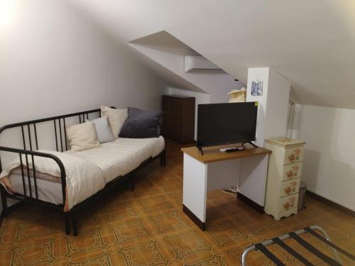1 dormitorio con 1 cama y TV en una mesa en La Maison Blanche, en Borghesiana 
