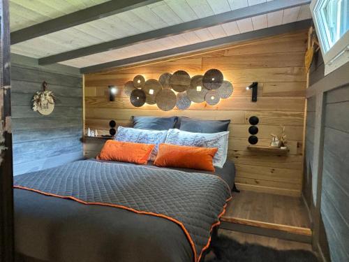 a bedroom with a bed in a room with wooden walls at TiNY HOUSE LE CHALET in Échenoz-la-Méline